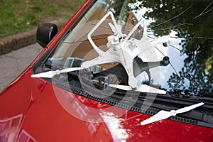 Damaged white drone on broken car windshield