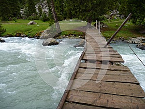 Damaged wooden bridge over a flooded stream