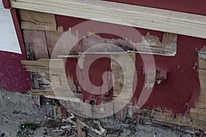 Damaged wooden panel with peeling paint.