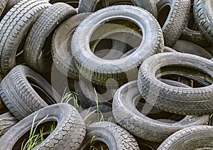 Damaged and worn old black tires on a stack. Damaged and worn old black tires on a stack. Tire tread problems. Solutions concept.
