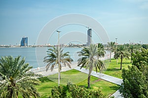 Dammam coastline corniche park with palms and developing city in the background, Saudi Arabia photo