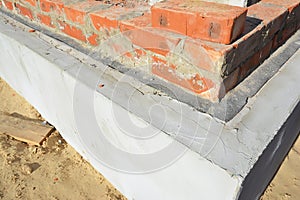 Damp proof membrane on top of foundation walls. Bitumen waterproof membrane for house foundation construction.