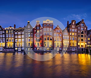 Damrak, Amsterdam, Netherlands. View of houses during sunset. The famous Dutch canals. A cityscape in the evening.