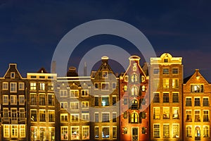 Damrak, Amsterdam, Netherlands. View of houses during sunset. The famous Dutch canals. A cityscape in the evening.