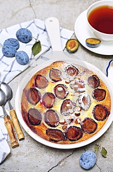 Damson blue plum clafoutis flan, icing sugar and and almonds dressing