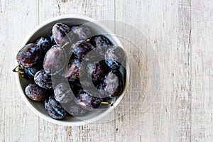 Damson Plum on white wooden surface.