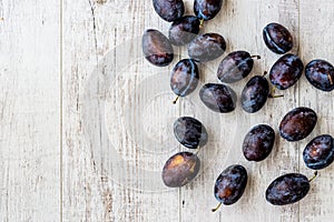 Damson Plum on white wooden surface.