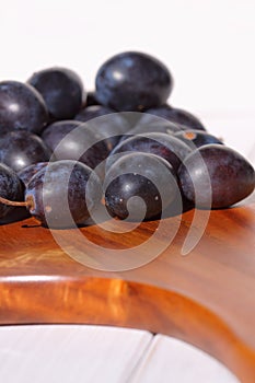 Damsons on wooden chopping board C