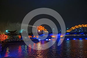 Danang bridge dragon spews water in the dark of night surrounded by the crowd of spectators