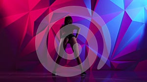 Dance booty with girl in shorts on bright graphic background. Slow motion