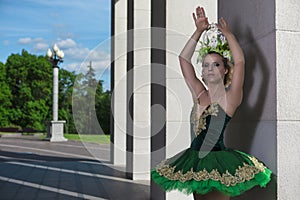 Dance Concepts. Winsome Professional Caucasian Ballet Dancer in Green Tutu Dress Posing in Dance on City Street