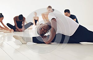 Dance enables you to find yourself. a group of ballerinas warming up before practicing their routine.