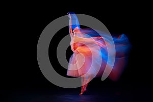 Dance of light and glow. Beautiful grace girl, female ballet dancer dancing isolated over black background in mixed neon
