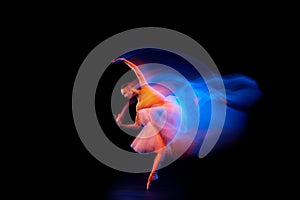 Dance of light and glow. Beautiful grace girl, female ballet dancer dancing isolated over black background in mixed neon