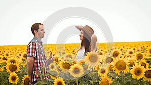 Dance man in and a girl a hat, on field with yellow sunflowers