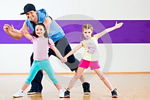 Dance teacher giving kids Zumba dancing class