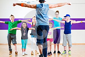 Dance teacher giving kids Zumba fitness class