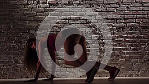 Dance twerk with woman in shorts against a brick wall. Slow motion. Close up