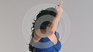A dancer in a chic blue dress is dancing elements of the incendiary dance of Argentine flamenco. Woman is dancing on a
