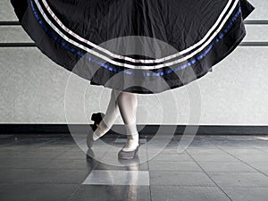 Dancer in Classical position with skirt held in character ballet attire