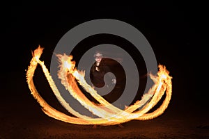 Dancer with flaming fire pois after dark.