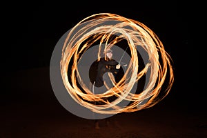 Dancer with flaming fire pois after dark.