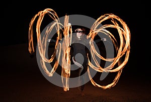 Dancer with flaming fire pois after dark.