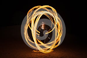 Dancer with flaming fire pois after dark.