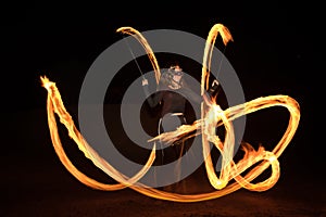 Dancer with flaming fire pois after dark.