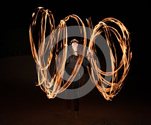 Dancer with flaming fire pois after dark.