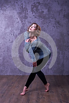 Dancer girl with short brown curly hair dance in the studio.