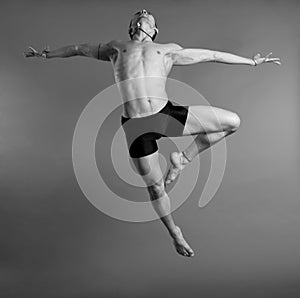 Dancer leaping over gray background