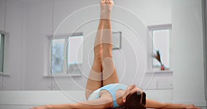 Dancer is lying on the floor of ballet studio and makes warm up exercises for legs, ballet dancer, ballerina in the