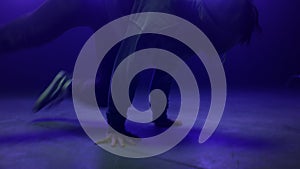 Dancer man performing breakdance in nightclub close up. Agile guy spinning body