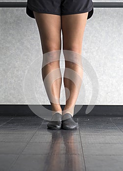 Dancer`s legs in jazz first position at the barre
