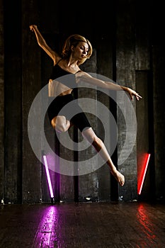 Dancer in studio, girl jumping and dancing, professional in black active wear