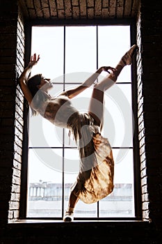 Dancer in studio, girl jumping and dancing  professional in light active wear