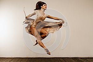 Dancer in studio, girl jumping and dancing  professional in light active wear