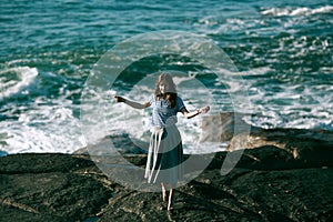 The dancer woman is engaged in choreography on rocky Alantic coast.