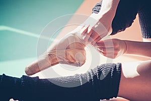 Dancer woman putting on ballet shoes closeup