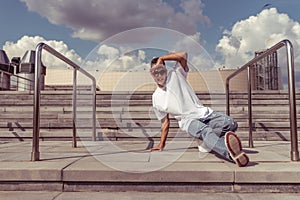 Dancer is young guy, in summer in city, dancing street dances, break movement, modern youth style. Fashion and fitness