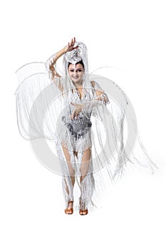 Beautiful young woman in carnival, stylish masquerade costume with feathers dancing on white studio background. Concept
