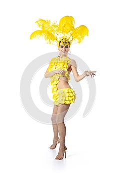 Beautiful young woman in carnival, stylish masquerade costume with feathers dancing on white studio background. Concept