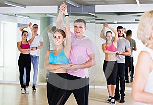 Dancing couples learning salsa at dance class