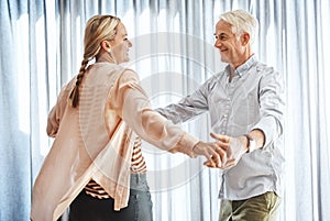 Dancing the day away. Cropped shot of an affectionate mature couple dancing in their home.
