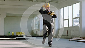 Dancing excited and charismatic man architect at the end of the day he enjoy the moment at construction site wearing