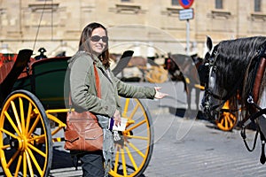 The happy woman among the horses and carriages photo
