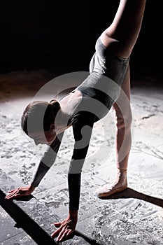 Dancing in flour. attractive female dancer in dark studio. female making dance element