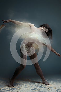 Long hair muscle man dancer in dust