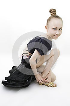 The dancing girl has sat down to clasp a shoe